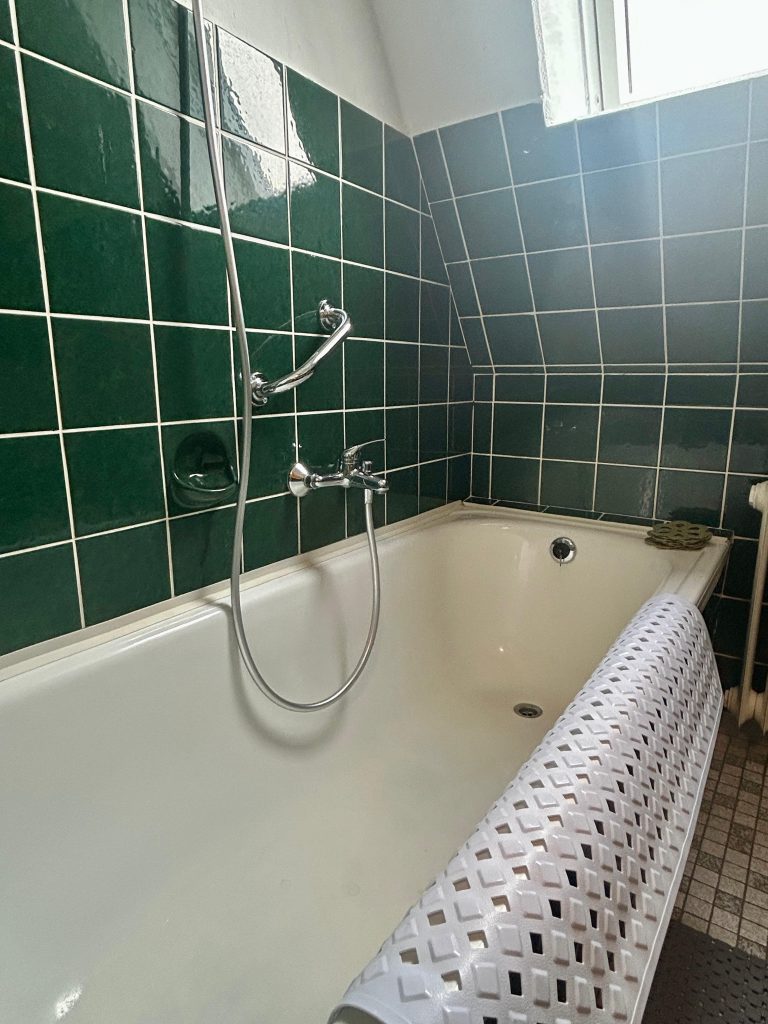 Badewanne mit integrierter Dusche in der Ferienwohnung Zur Mühle in Burhave