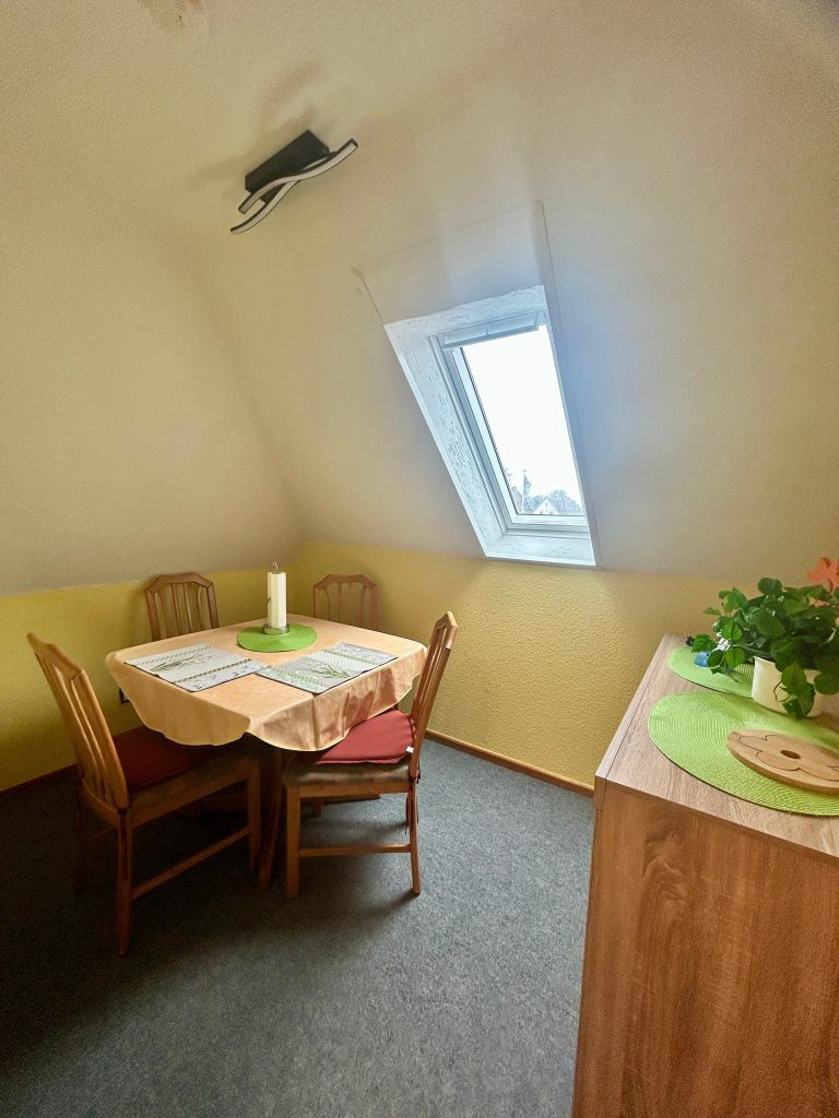Esstisch für vier Personen unter dem Dachfenster der Ferienwohnung in Burhave